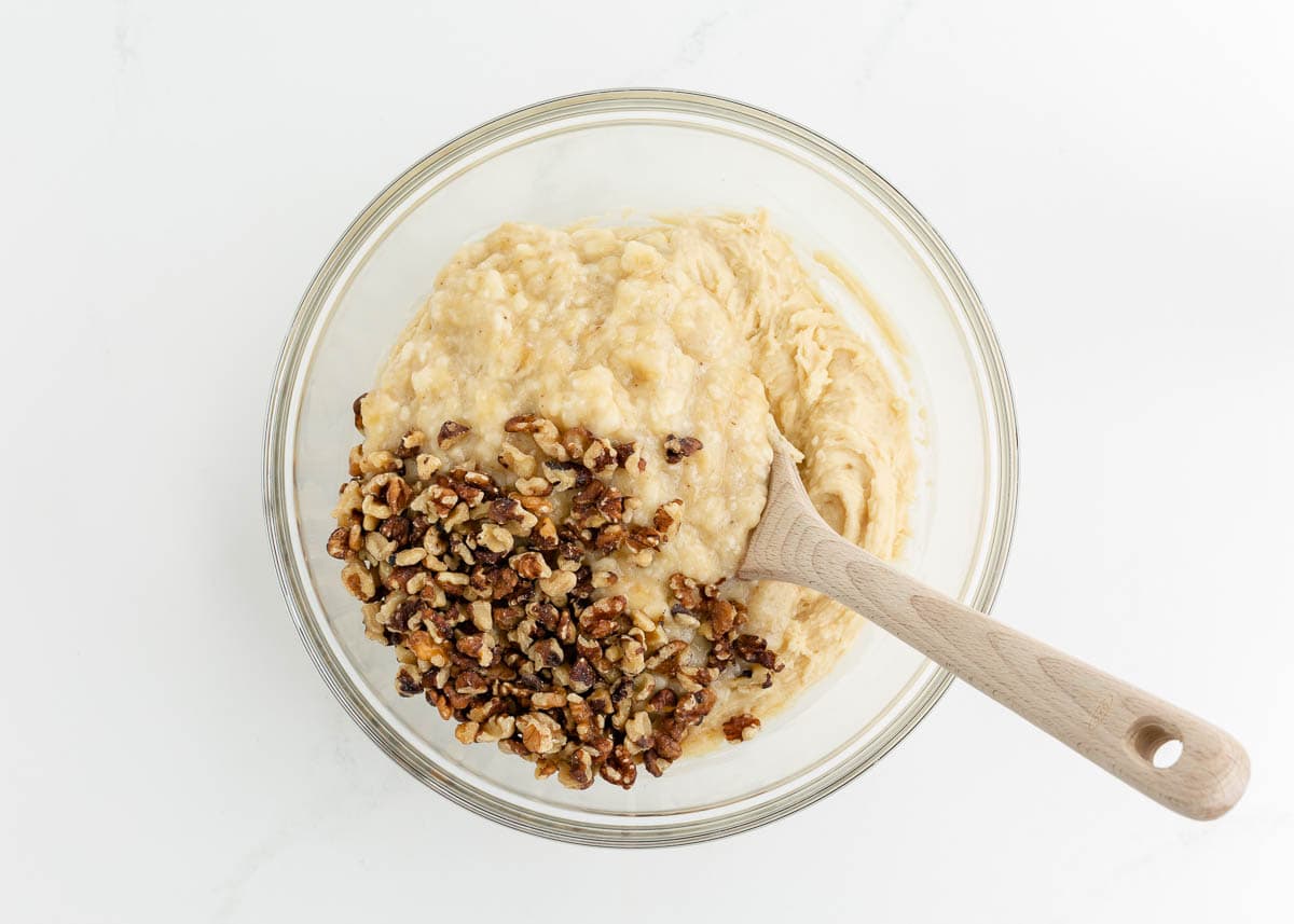 Banana bread batter with nuts in a bowl.