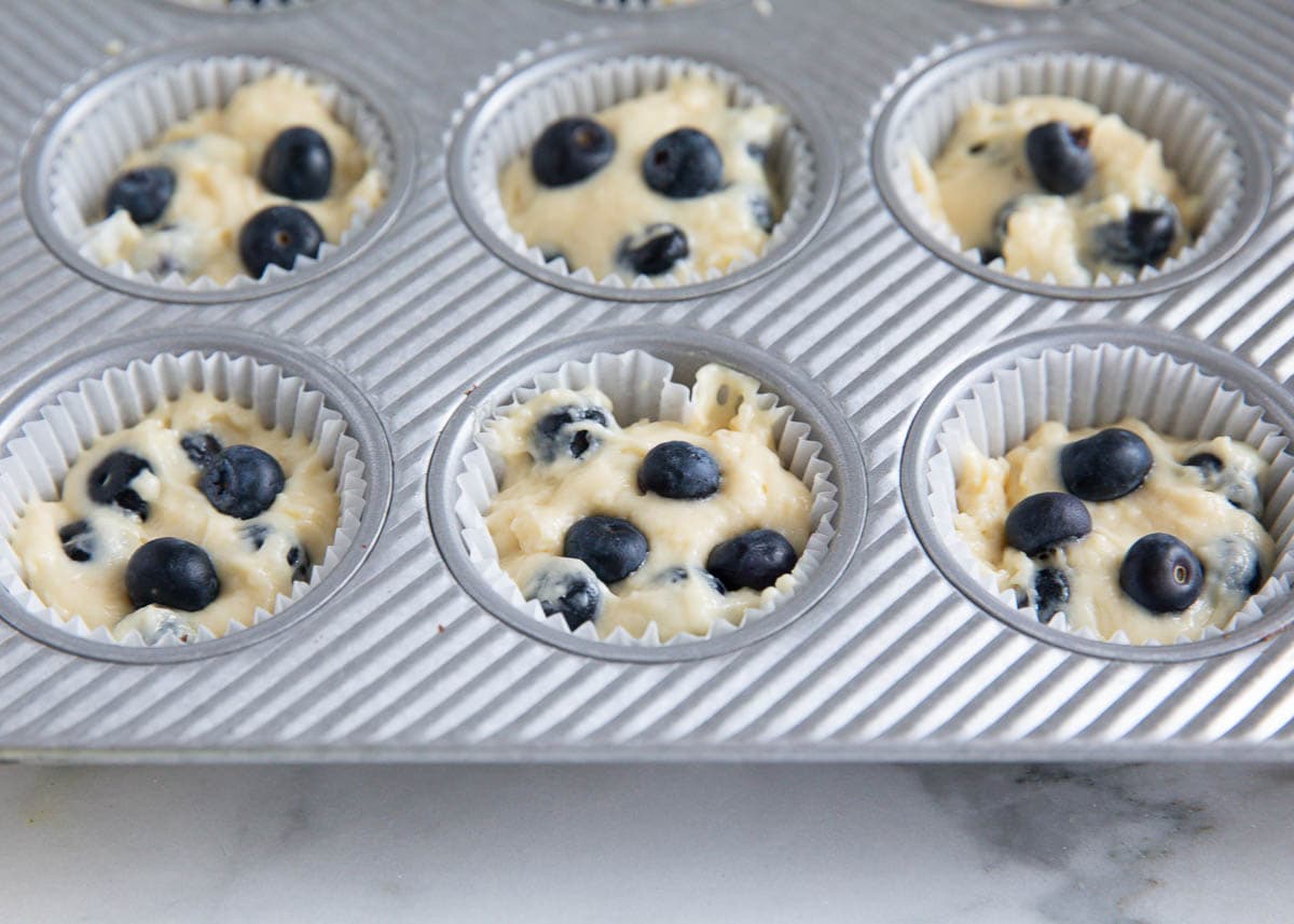 Unbaked lemon blueberry muffins in a muffin tin.