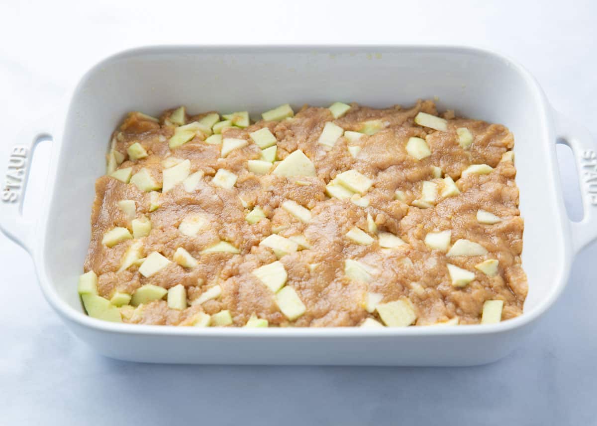 Unbaked apple cake in a baking dish.