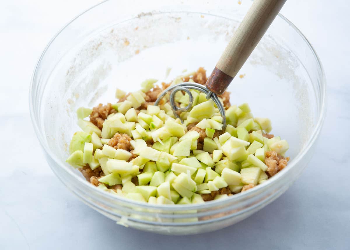 Adding fresh chopped apples to cake batter.