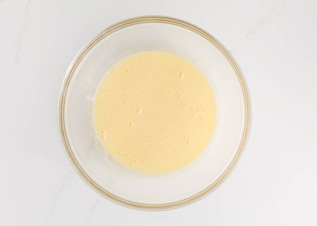 Buttermilk, sugar and eggs in a bowl.