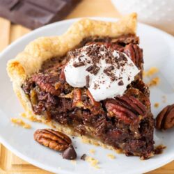 Slice of chocolate pecan pie on a white plate.