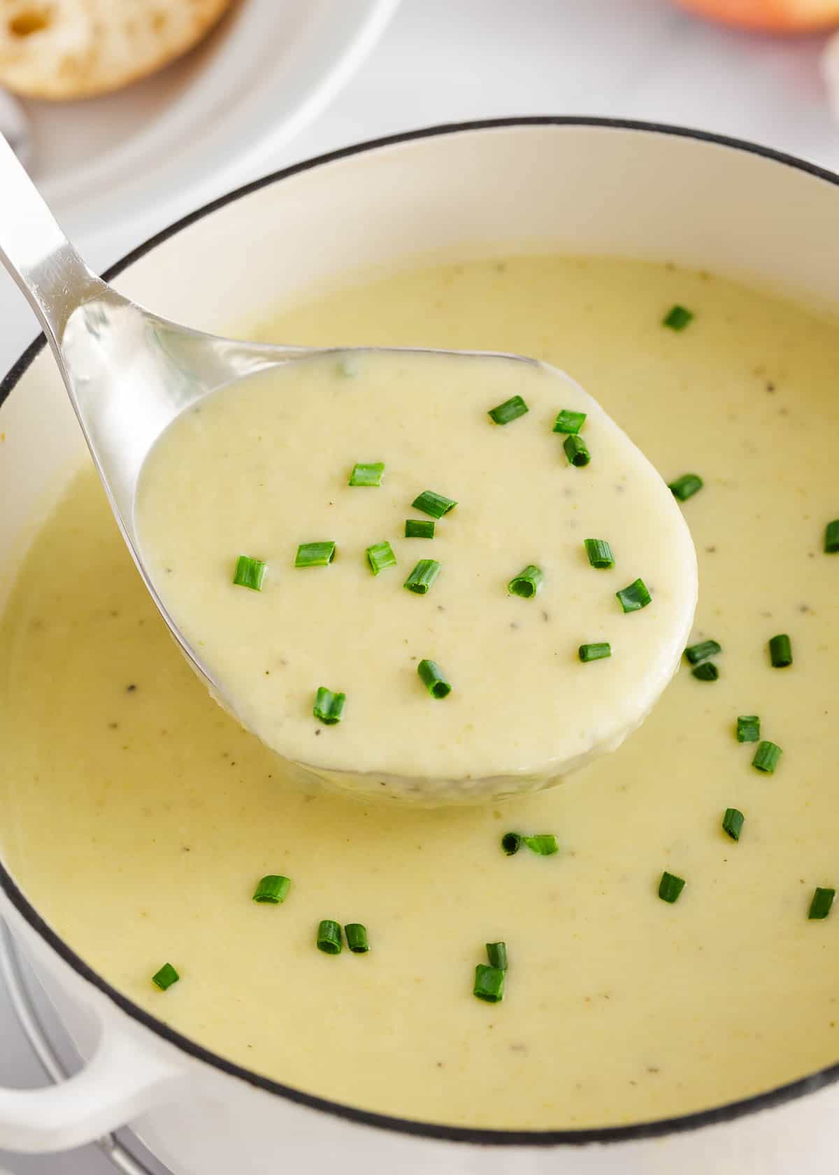 Potato leek soup being served out of a large pot. 