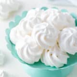 Meringue cookies in a colored bowl on the counter.