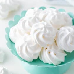 Meringue cookies in a colored bowl on the counter.