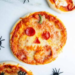 Jack o lantern pizza on a counter.