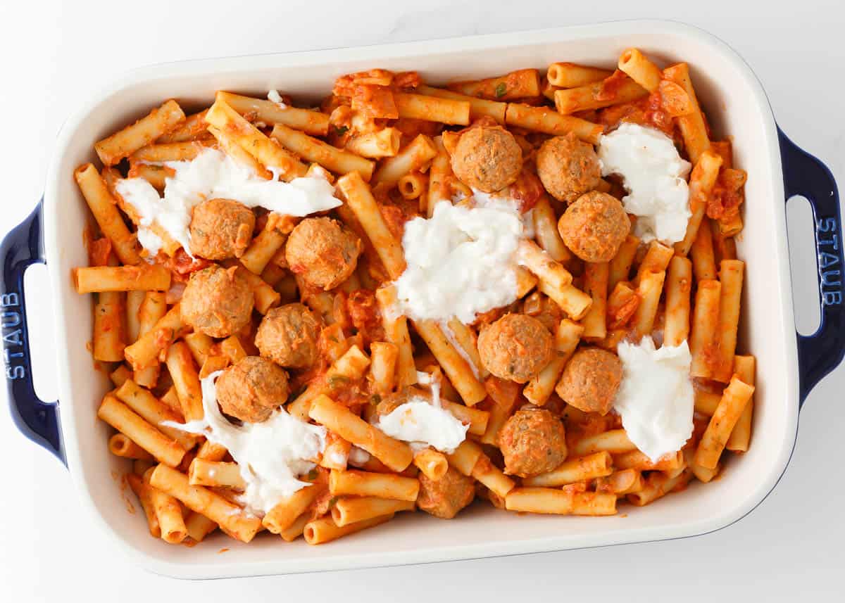 Unbaked baked ziti with meatballs.