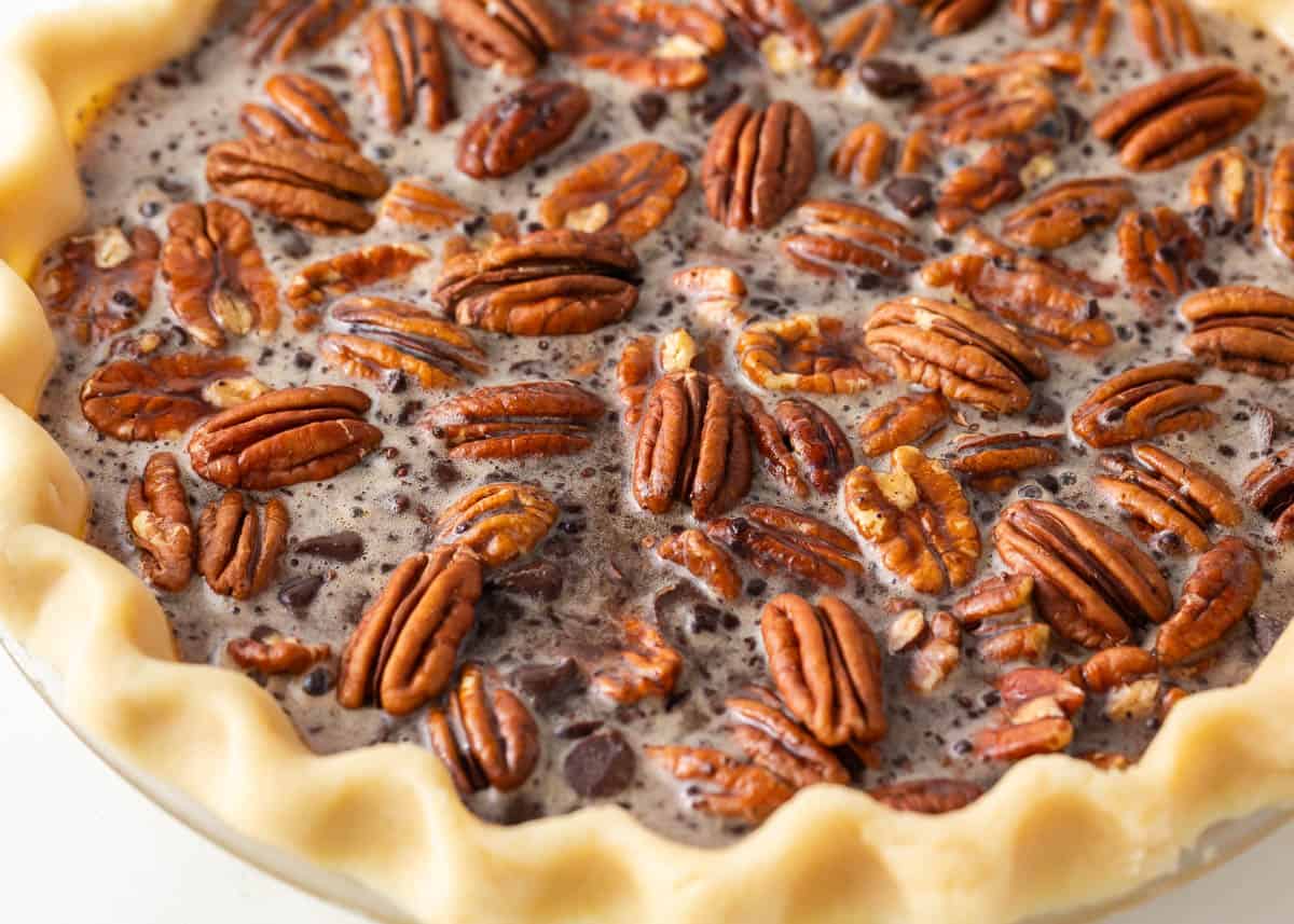 Unbaked filling in chocolate pecan pie.