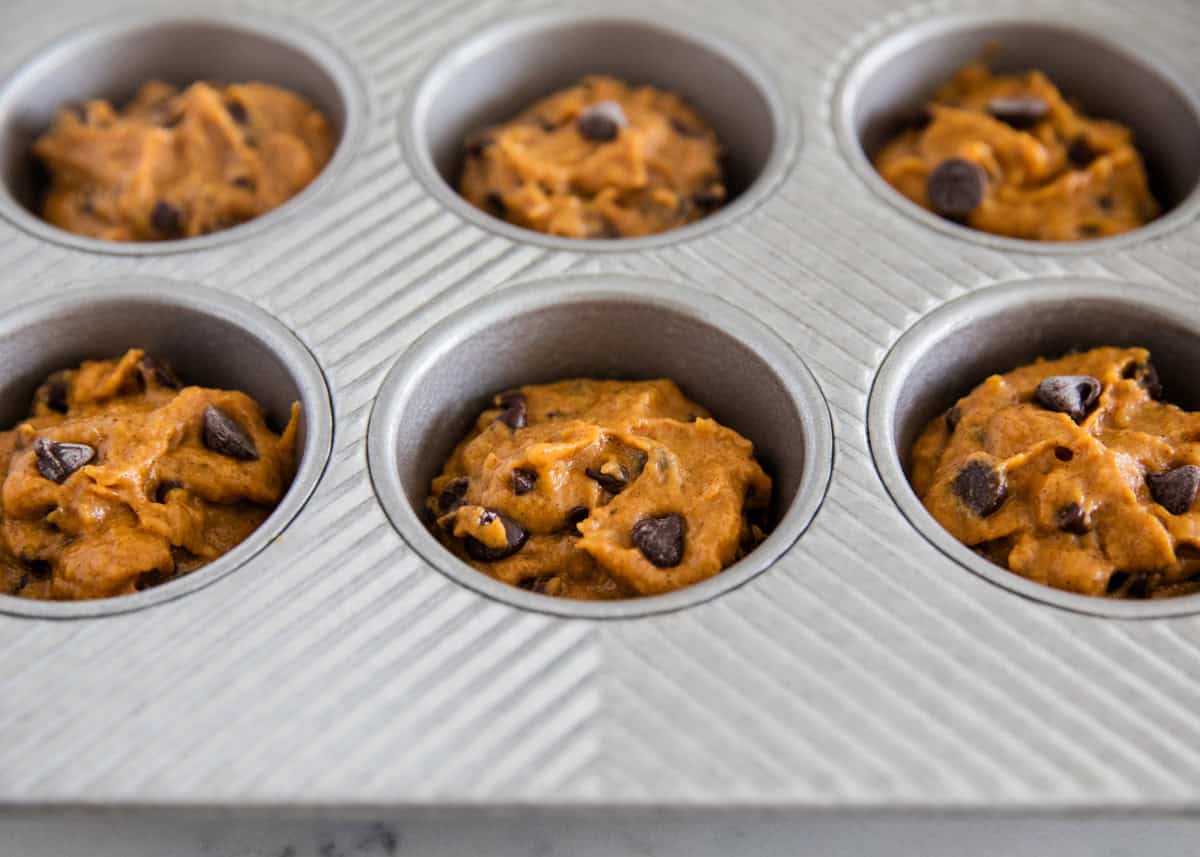 Unbaked pumpkin chocolate chip muffins in a muffin tin.