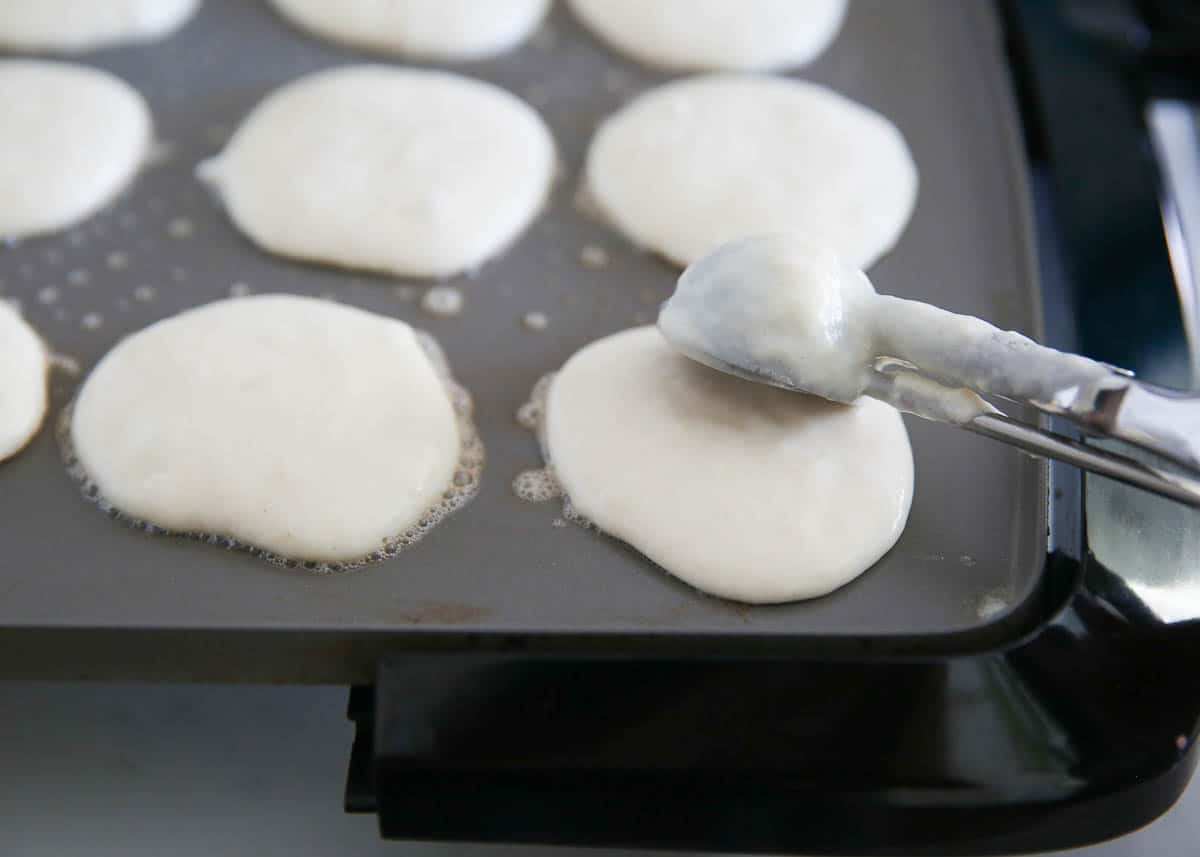 Mini pancake batter on a griddle.