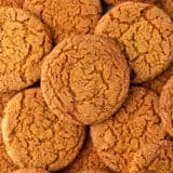 A close up of crispy gingersnap cookies showing the crackly top of the cookie.