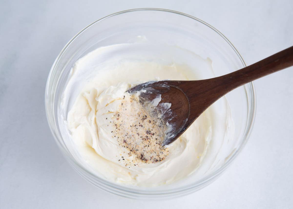 Cream cheese and seasonings in a bowl.