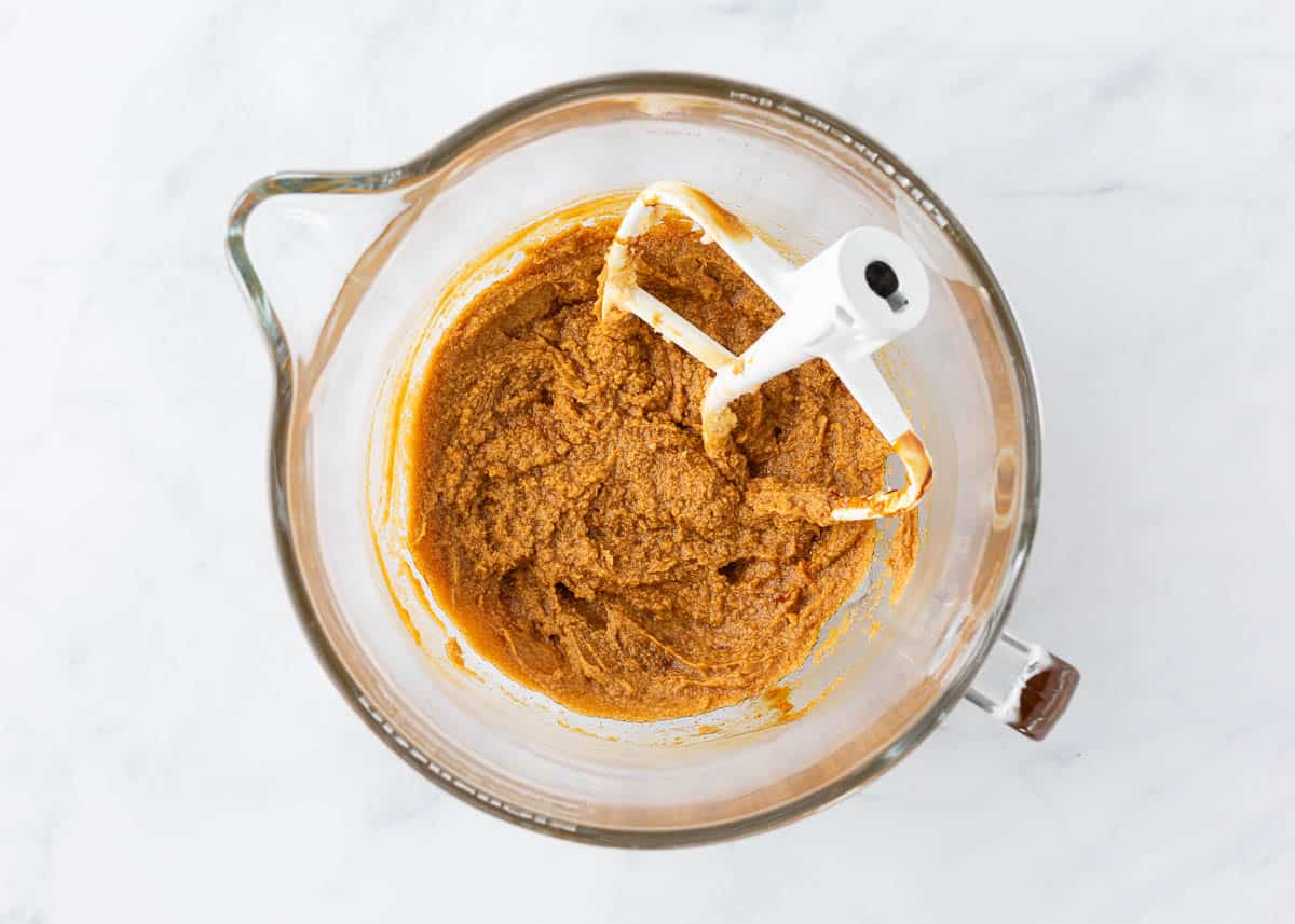 Butter and brown sugar with molasses in a bowl with the paddle attachment from a stand mixer.