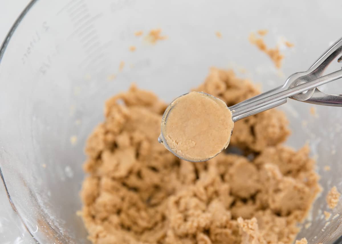 Peanut butter, powdered sugar and butter being scooped.