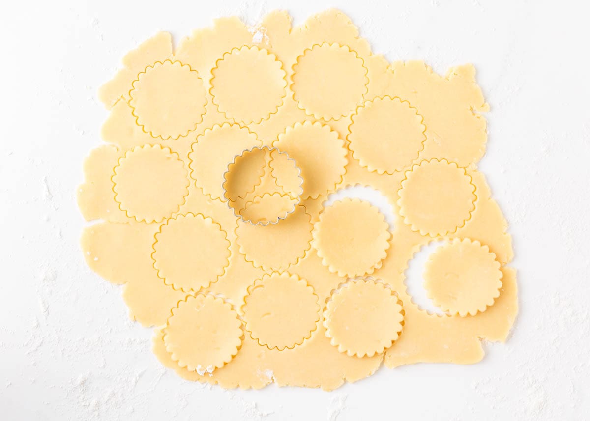 Using cookie cutters to cut out dough.