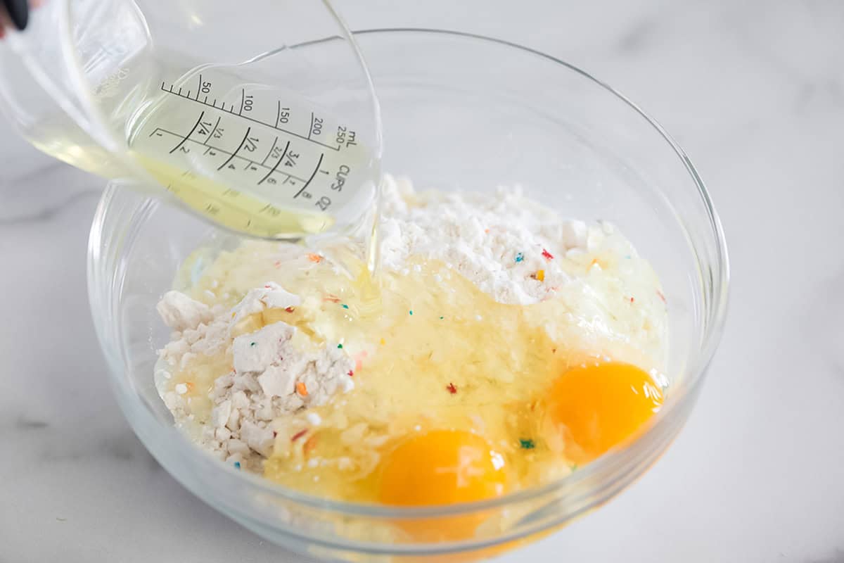 Funfetti cake mix, eggs and vegetable oil in a bowl.