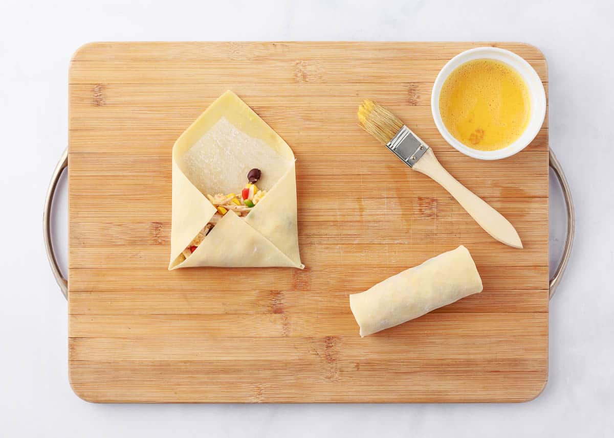 Egg roll wrapped being filled with southwestern filling.