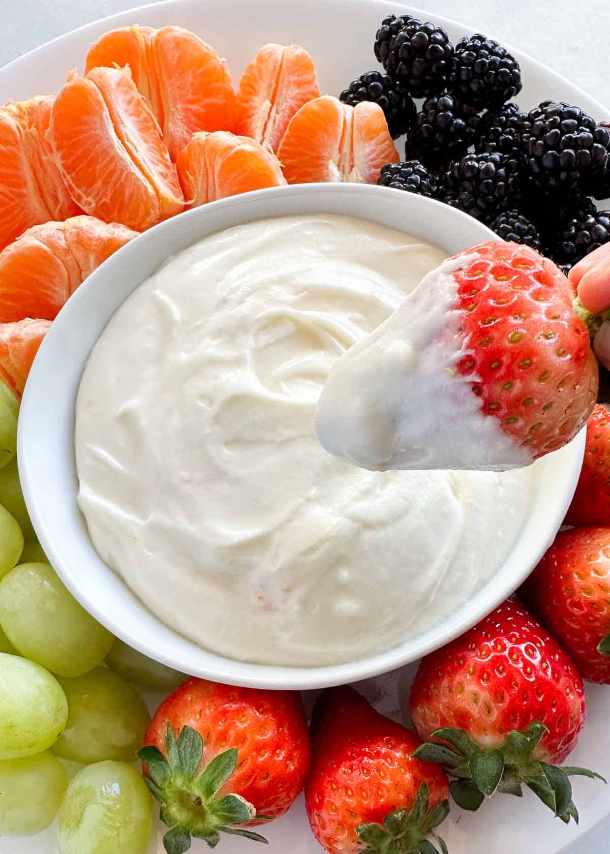 Dipping strawberry into fruit dip.