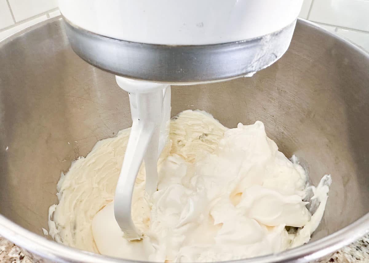 Mixing cream cheese in a mixing bowl.