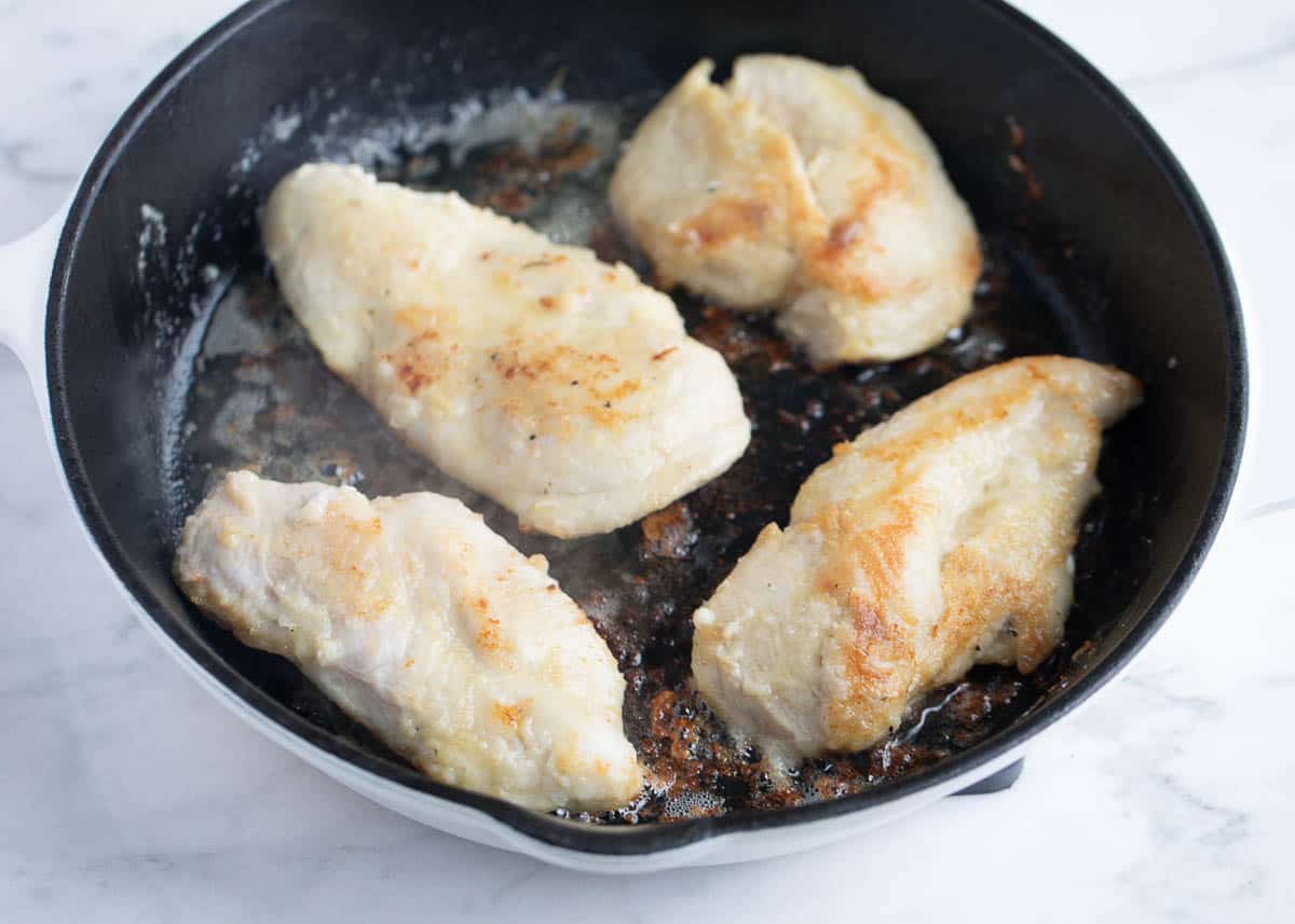 Cooking chicken in a skillet.