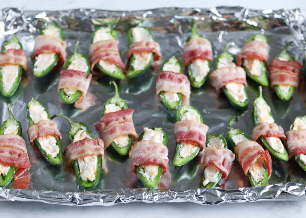 Unbaked jalapeno poppers wrapped in bacon.