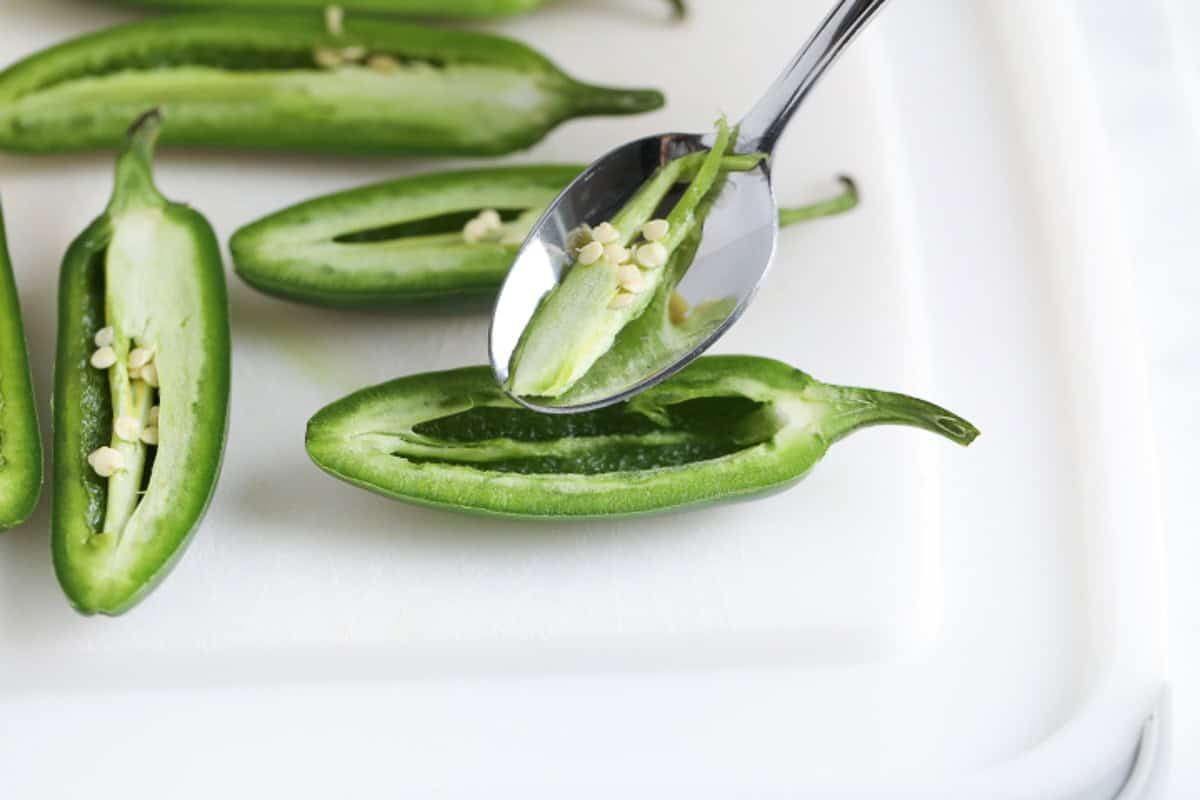 Removing seeds from jalapeno poppers.