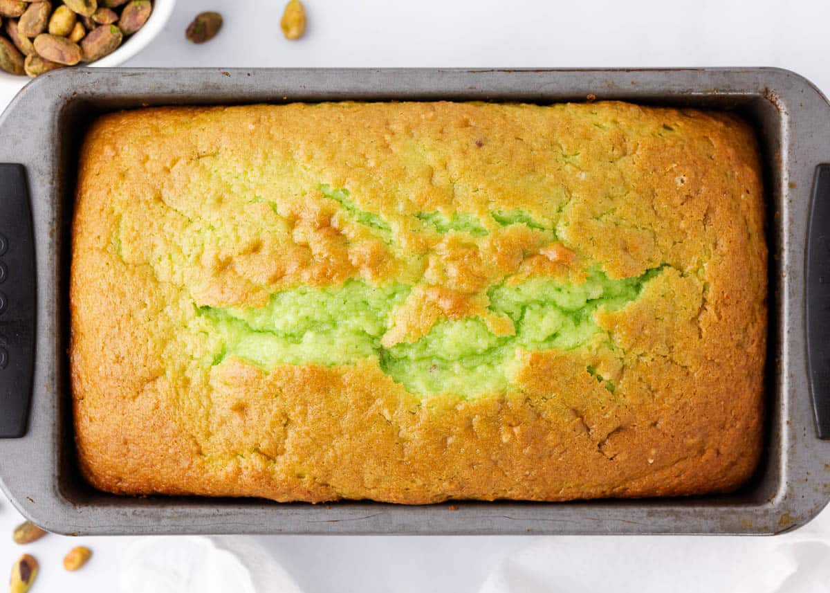 Baked pistachio quick bread in a loaf pan.