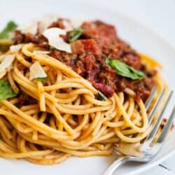 Spaghetti bolognese sauce with pasta on a white plate.