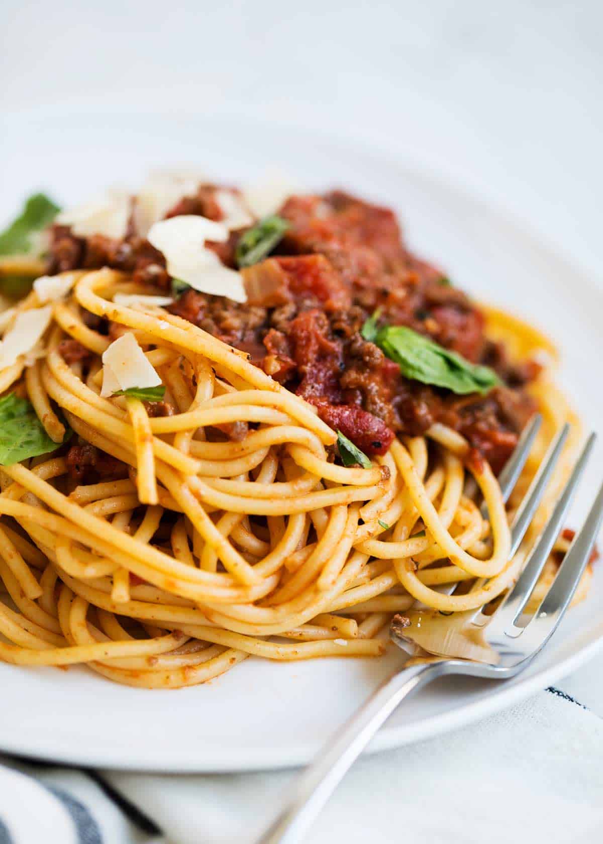 Spaghetti bolognese sauce with pasta on a white plate.