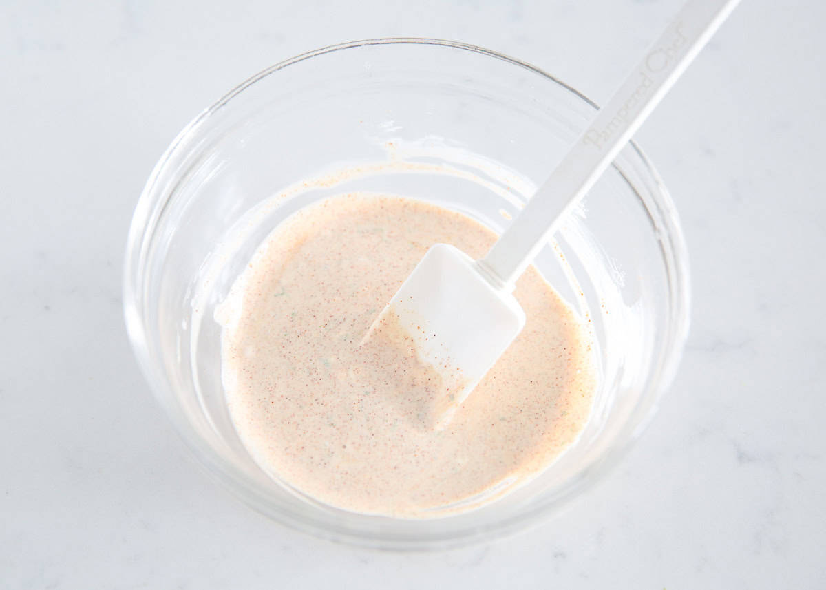 Mexican street corn salad dressing ingredients in a bowl.