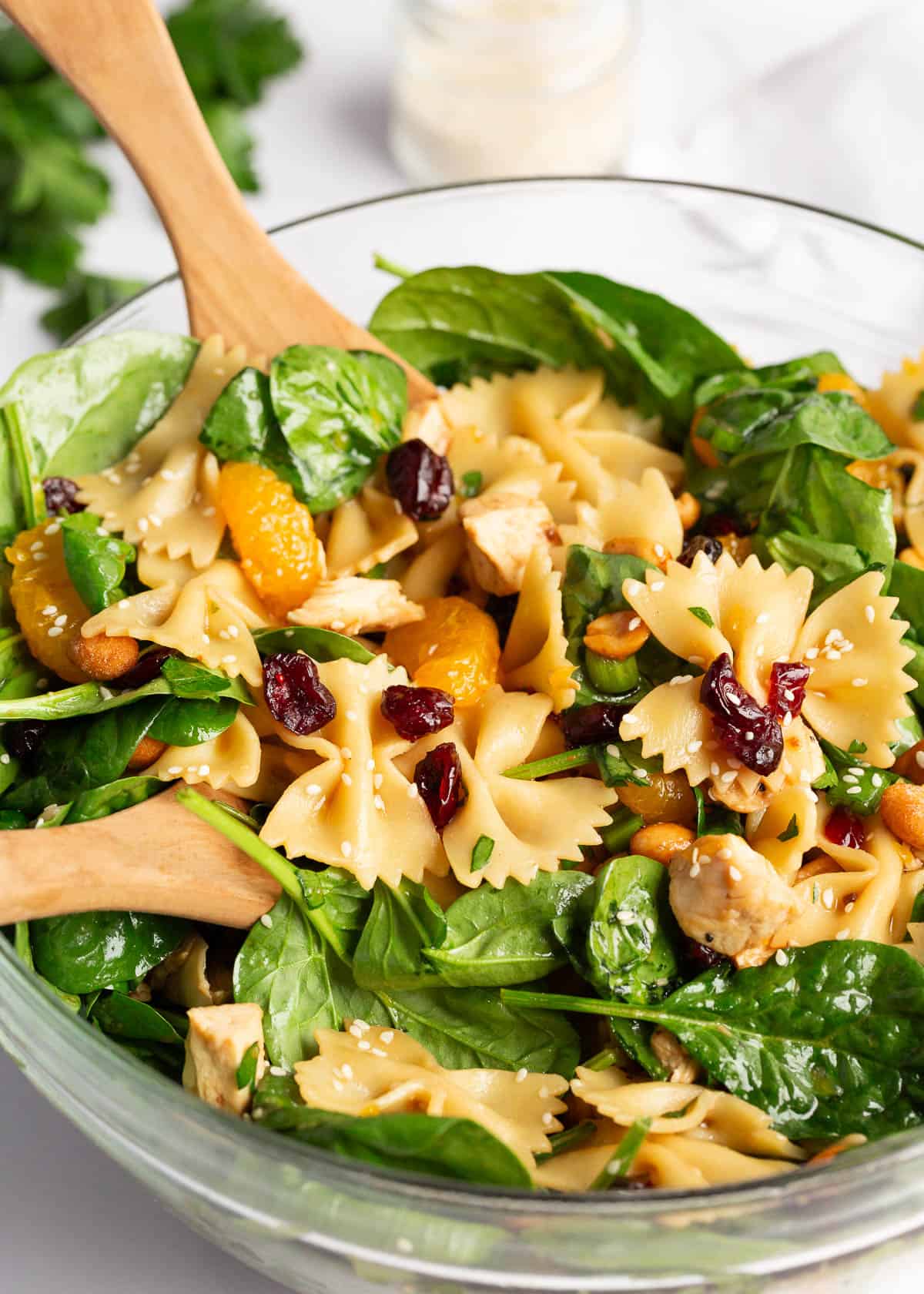 Tossing spinach salad in a bowl.