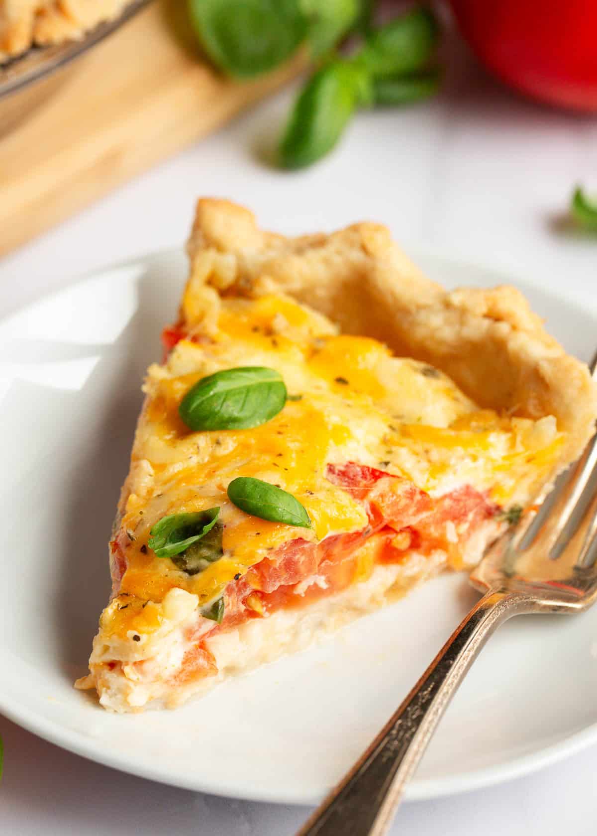 Slice of tomato pie on a plate.