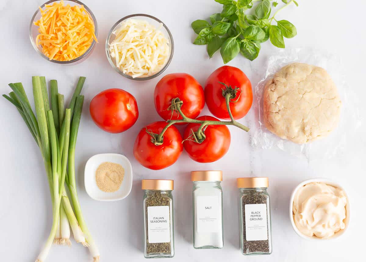 Tomato pie recipe ingredients on the counter.