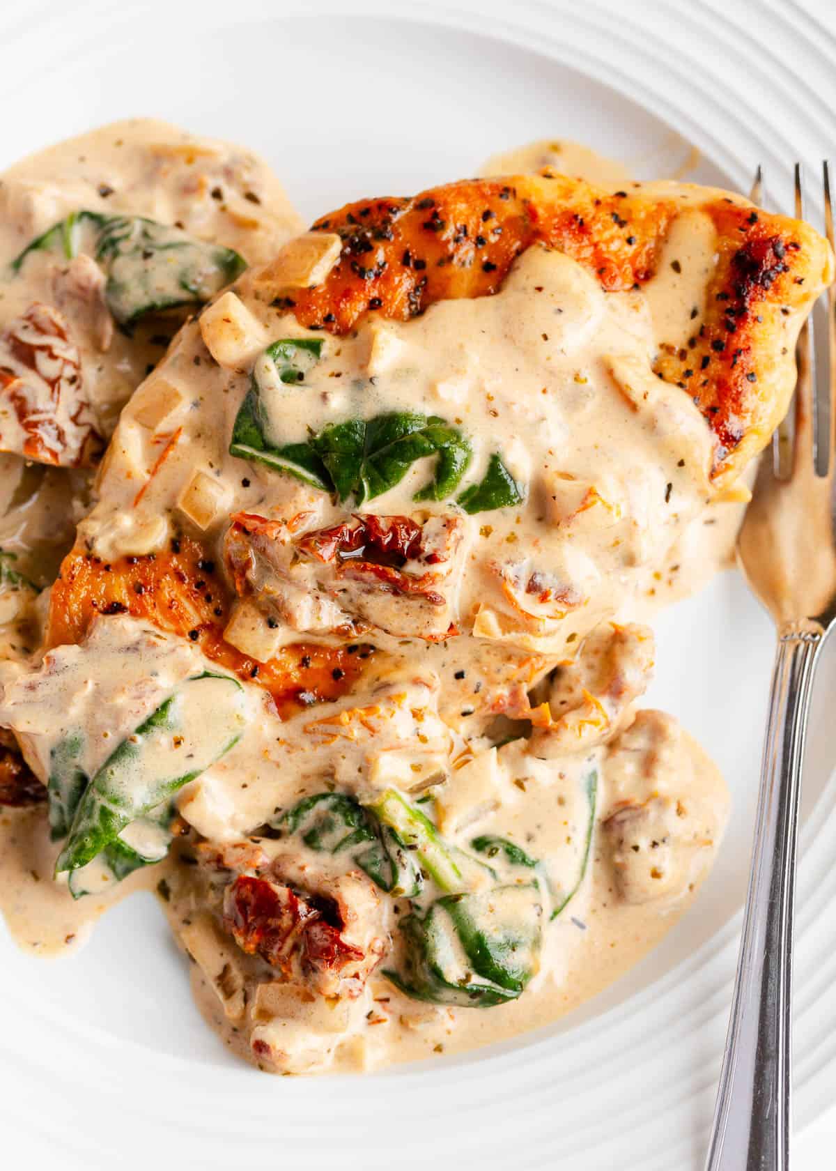 Tuscan chicken on a white plate.