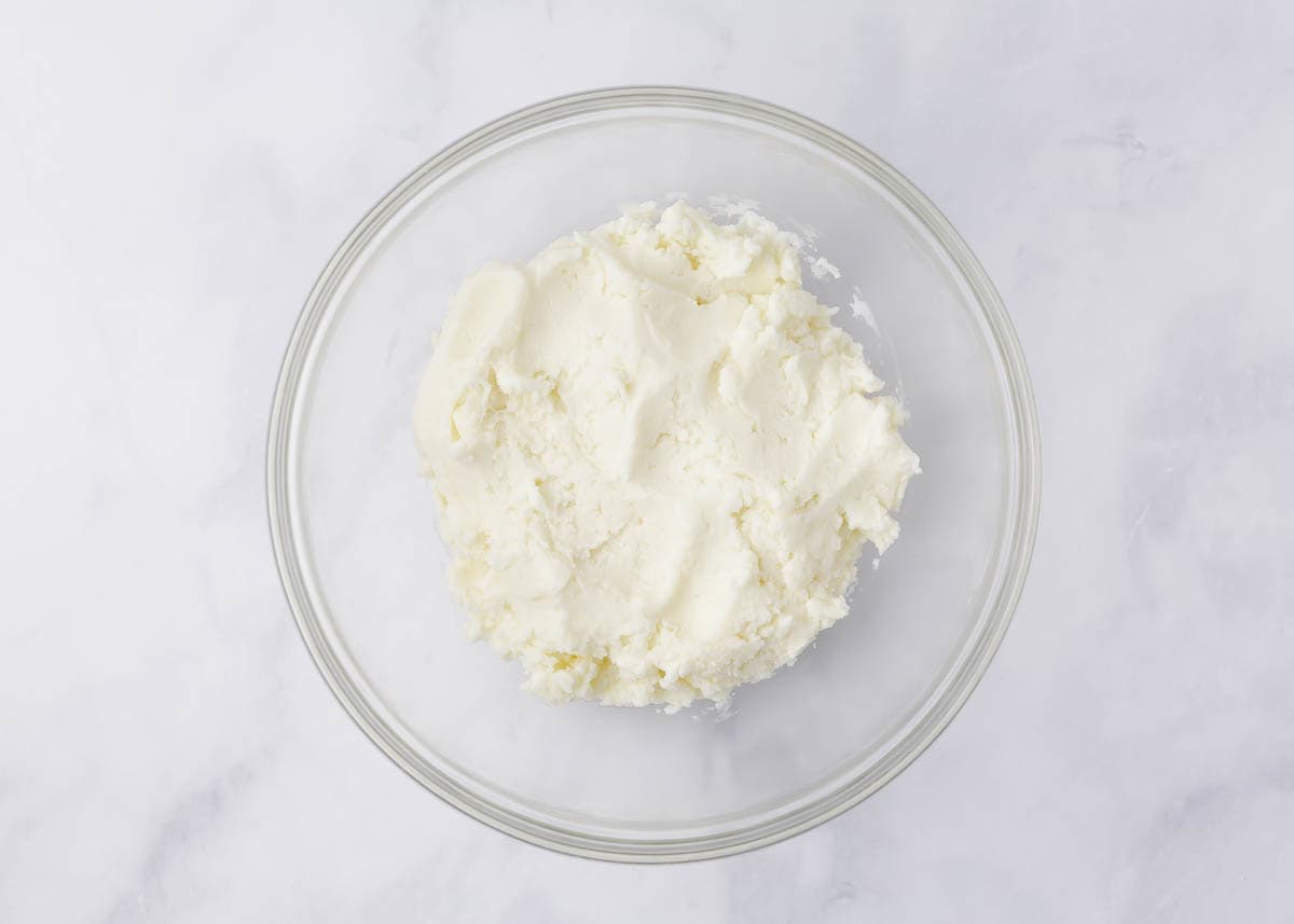 Cream cheese, butter and powdered sugar mixed together in a bowl.