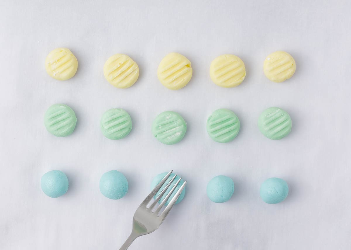 Using a fork to press a design into cream cheese mints.