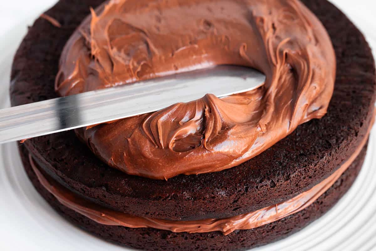 Spreading frosting on chocolate cake.