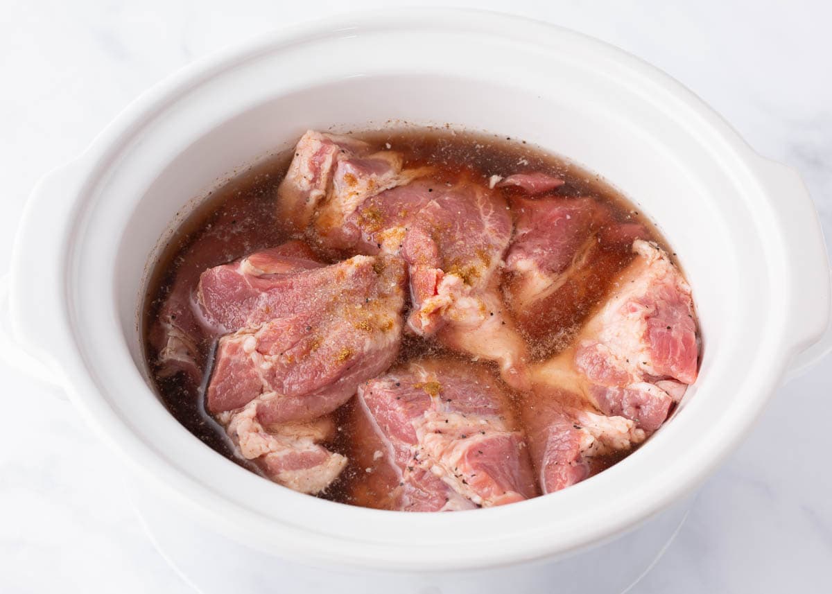 Pork in crockpot with sauce.