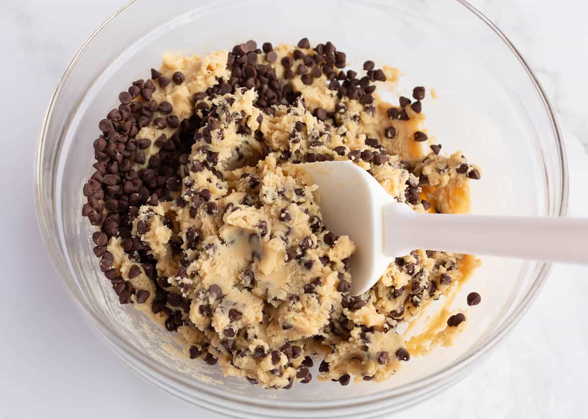 Folding mini chocolate chip cookies into the dough.