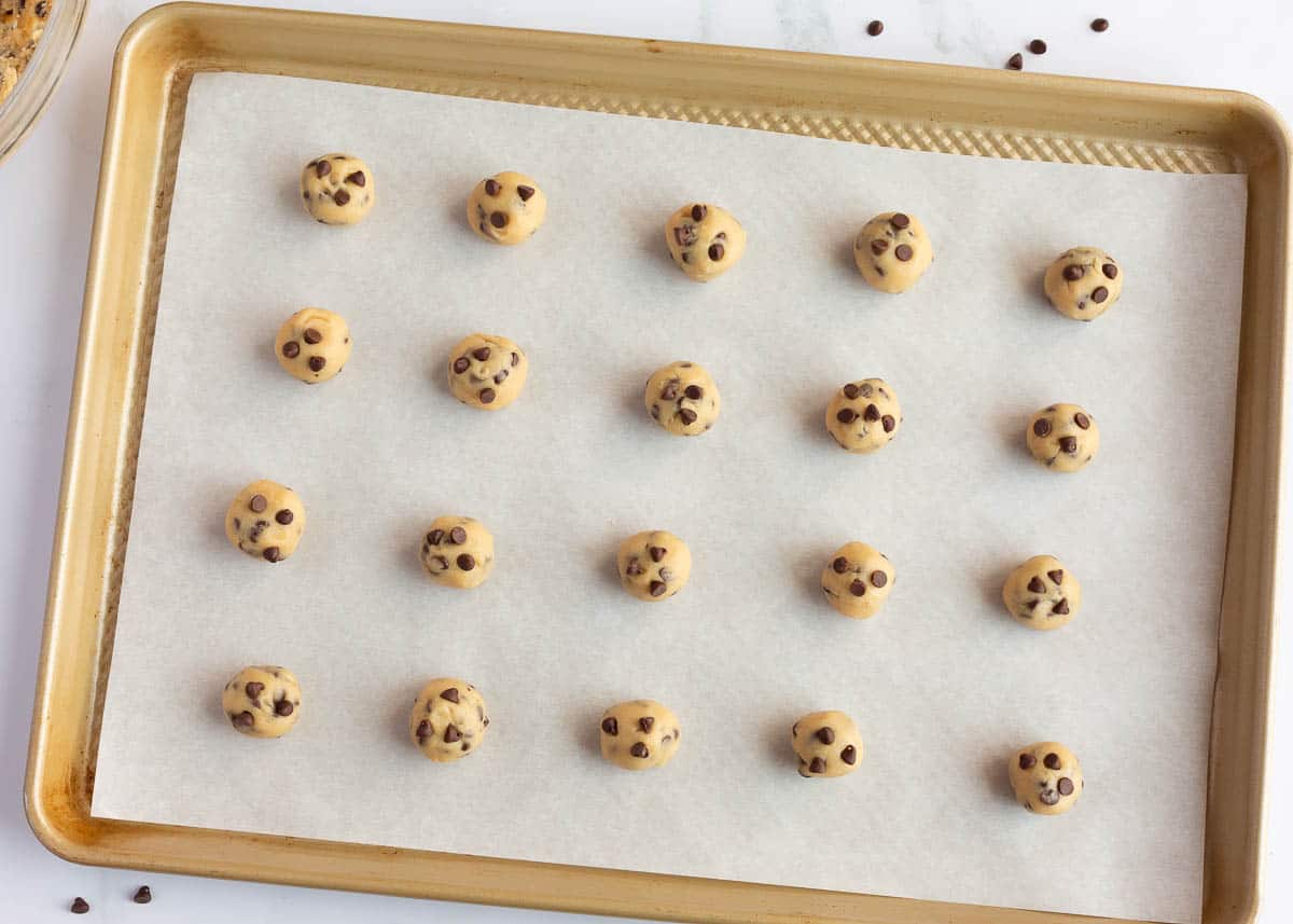 Mini chocolate chip cookie dough on a baking sheet.