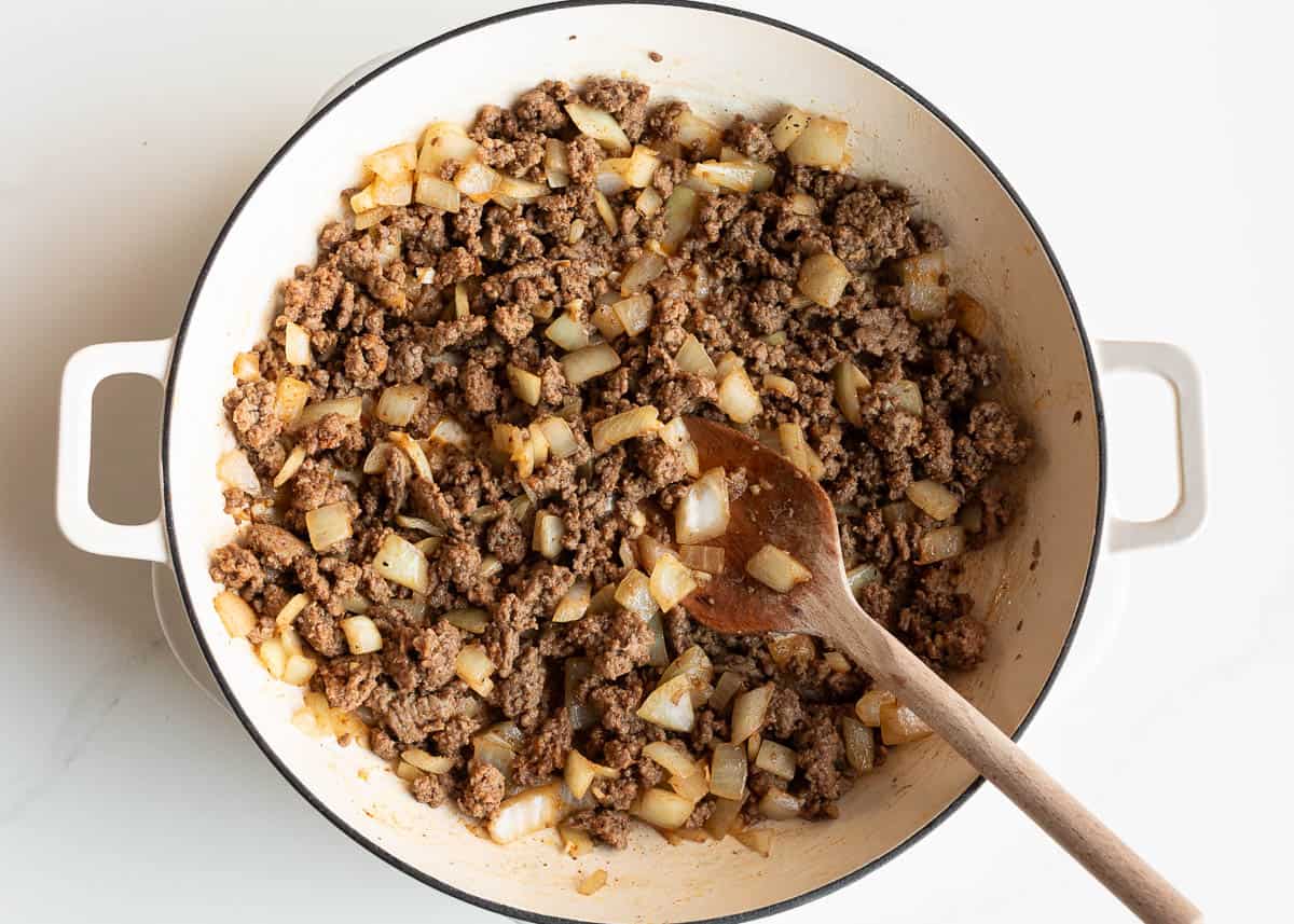 Browning ground beef with onion in a skillet.