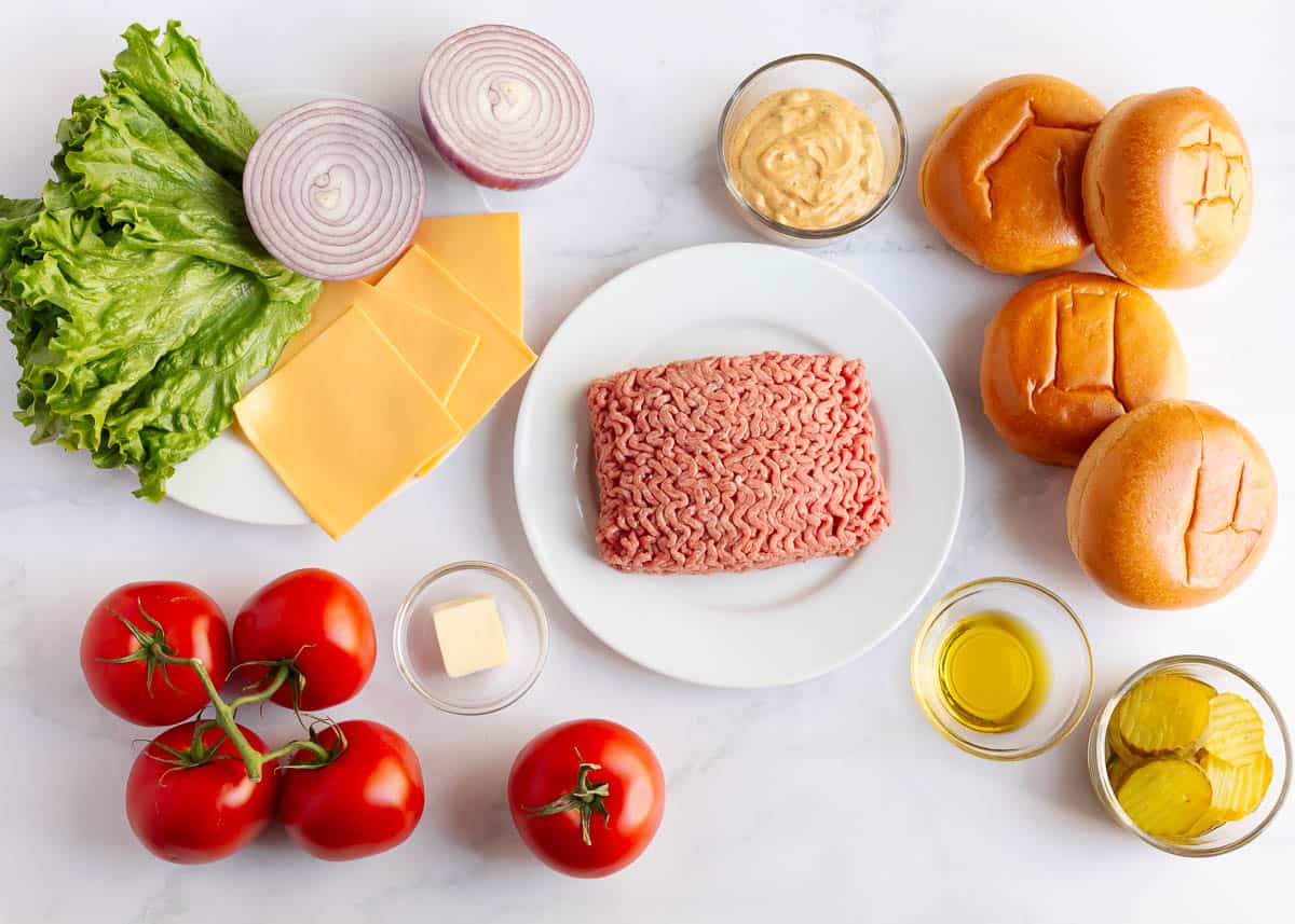 Ground beef, cheese, oil, butter, buns, tomatoes, lettuce, onion, pickles and sauce for smash burgers.