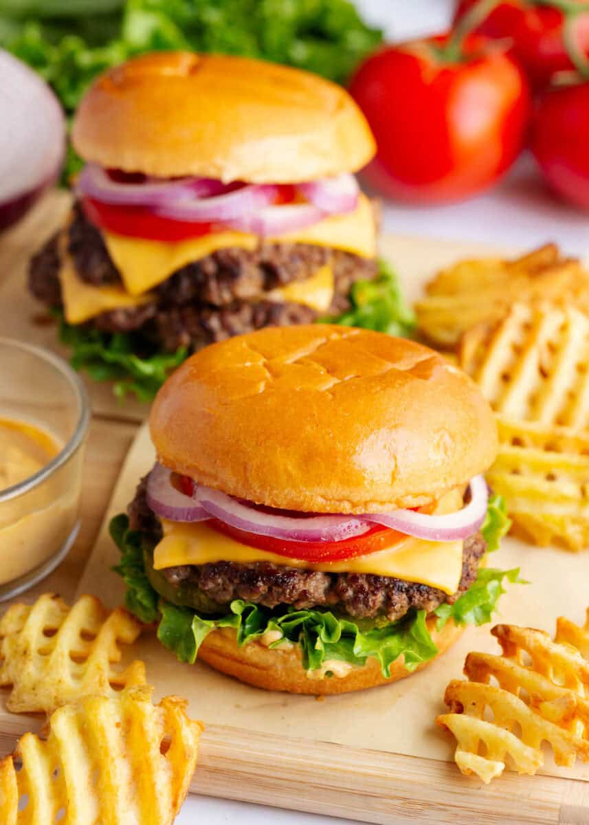 Two smash burgers on a cutting board.