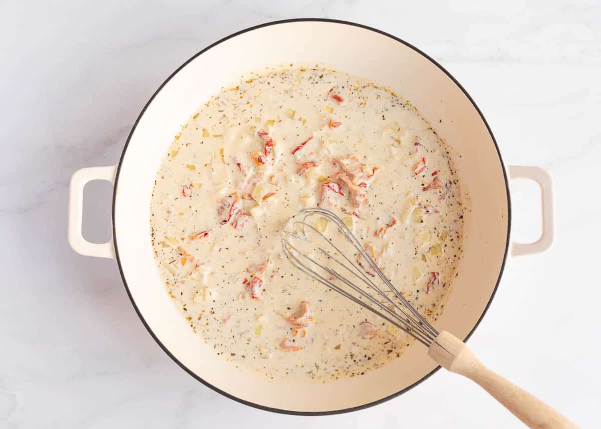 Cream sauce for Tuscan salmon in a skillet.