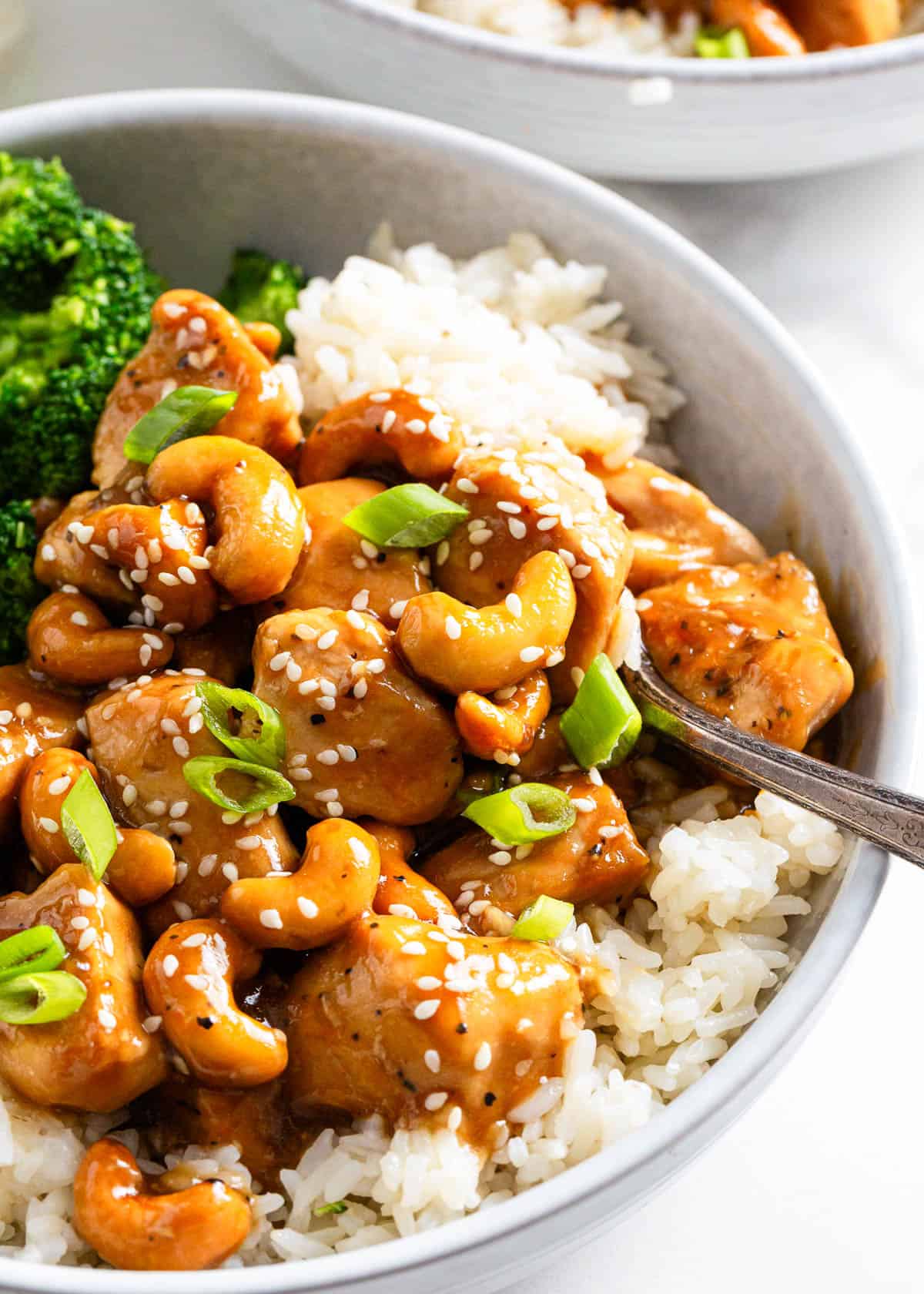 Cashew chicken in a bowl with a serving spoon.