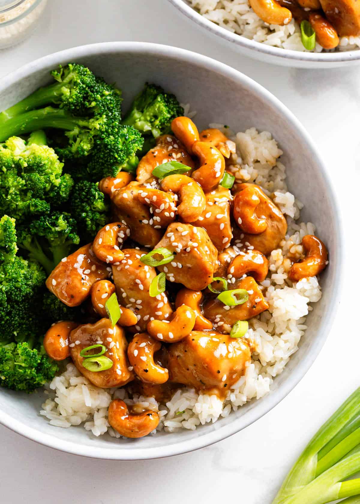 Cashew chicken in a bowl with rice and broccoli.