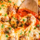 Chicken parmesan meatballs in pan with serving spoon.