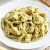 Chicken pesto pasta on a white plate.