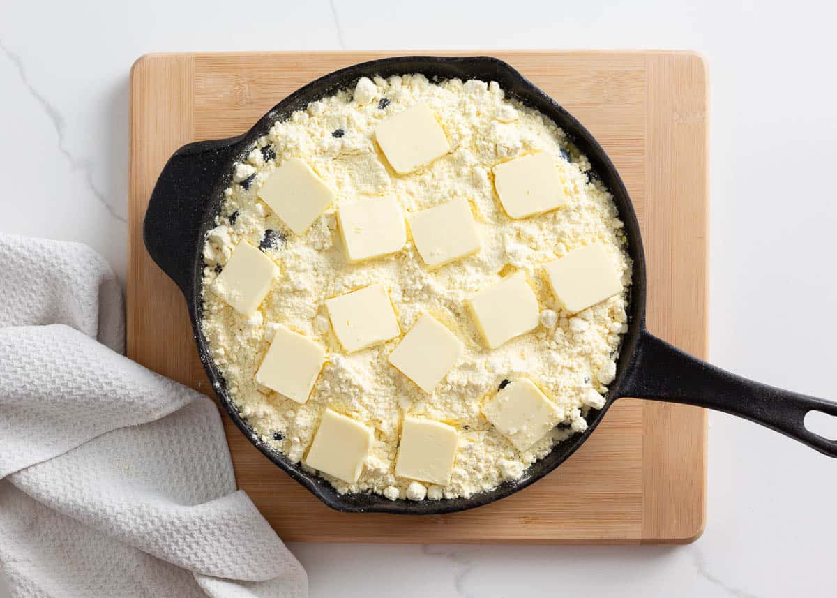 Blueberries, cake mix and butter in a large oven safe pan.