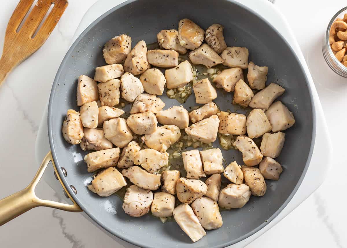 Cubed chicken breast in a skillet.